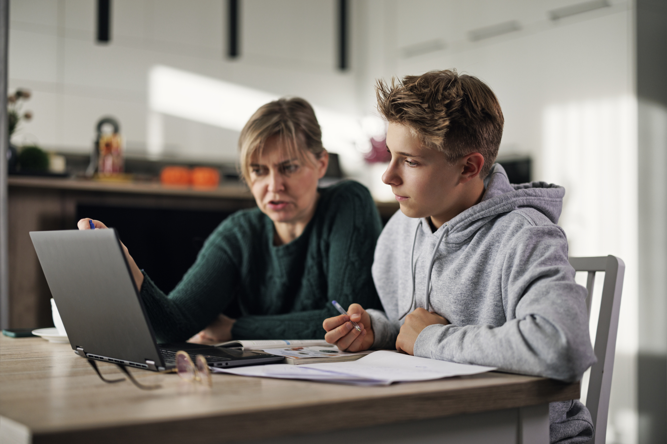 Mom teaching child at home table